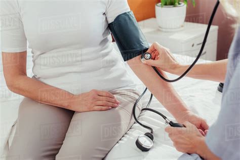 Close Up Partial View Of Nurse Measuring Blood Pressure To Senior