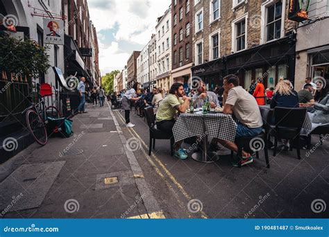 People Sitting On The Busy Restaurant Terrace In Soho Area During