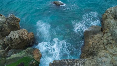 Upper View Sea With Waves Breaking And Frothing On A Rocky Beach Stock