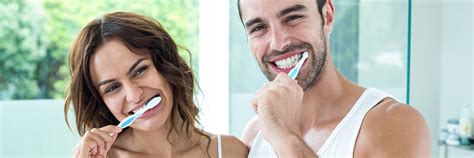 Happy Couple Smiling And Brushing Their Teeth Silverwood Dental