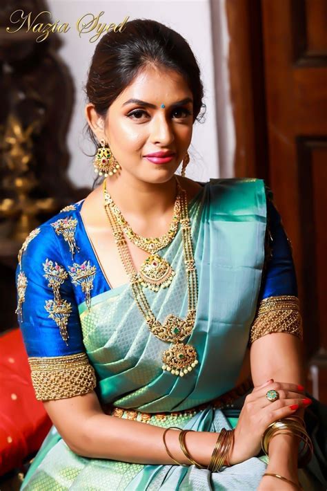 in a bridal look in a blue color pattu kanjeevaram saree dark blue color elbow leng