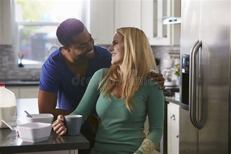 Mixed Race Couple In Kitchen Look Closely At Each Other Stock Image