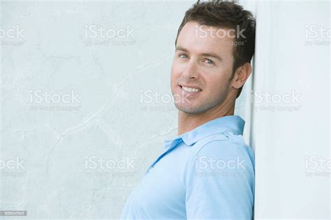 Happy Young Man Leaning Against Wall Stock Photo Download Image Now