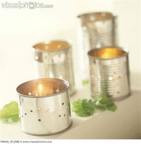 Display Of Recycled Pierced Tin Can Holders With Burning Candles