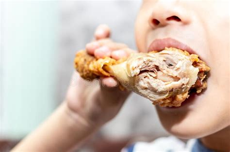 Hungry Little Boy Eating Chicken Leg Child Hand Holding A Fried
