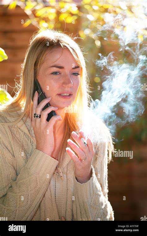 Young Woman Smoking A Cigarette In Her Garden Stock Photo Alamy