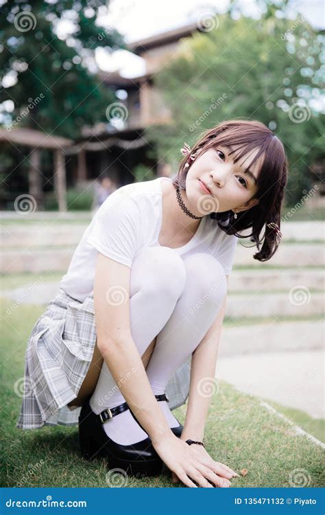 Portrait Of Asian Girl With White Shirt And Skirt Looking In Outdoor