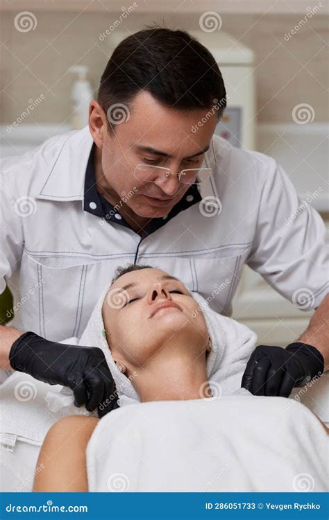 Beautician Cleanses Skin Of Woman With Cotton Sponge Stock Image