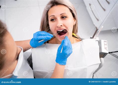 Professional Dentist Examines And Treats Damaged Teeth Using Special