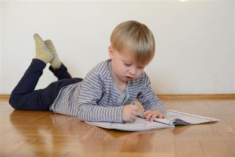 Premium Photo Cute Boy Reads The Book On The Floor At Home