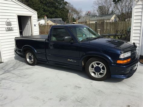 A Blue Truck Parked In Front Of A Garage