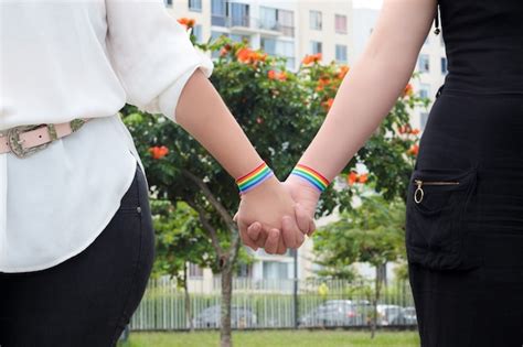 premium photo two lesbian girls holding hands wearing pride flag
