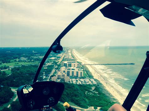 an aerial view of the beach and ocean from inside a small plane with