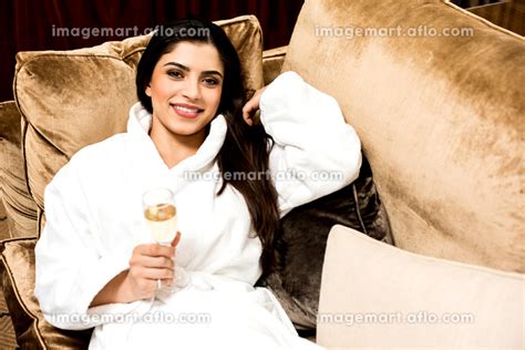 Relaxed pretty woman enjoying champagneの写真素材 イメージマート