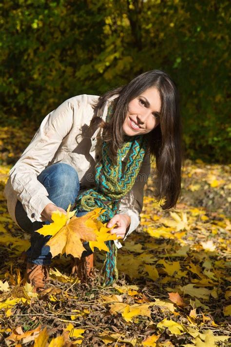Happy Young Woman On A Walk In Autumn Holding Leaves In Her Hand Stock