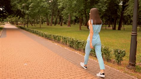 Back View Of A Woman Walking On A City Park Stock Video At Vecteezy