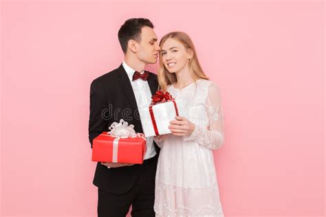 Couple In Love Man And Woman Give Each Other Ts On Pink Background Valentines Day Concept