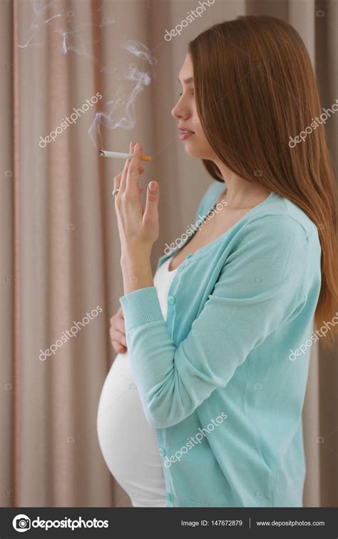 mujer embarazada fumando cigarrillo en el fondo cortinas fotografía de stock © belchonock