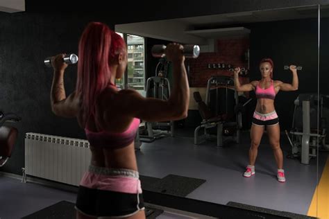 Premium Photo Woman Exercising Shoulders With Dumbbells In The Gym