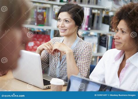 Group Of Mature Students Collaborating On Project In Library Stock