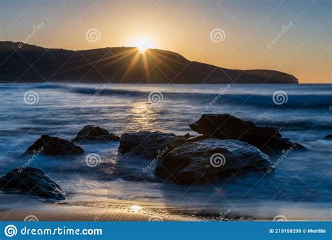 Sunrise At The Seaside With Clear Skies And Sunburst Stock Image