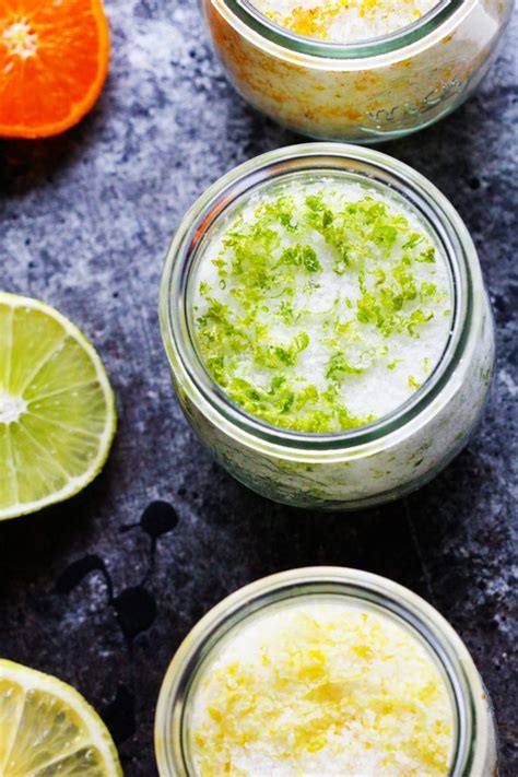 Three Jars Filled With Different Types Of Food And Garnished With Lime Cilantro And Orange Slices