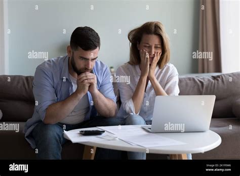 Frustrated worried millennial husband and wife reading bankrupt message