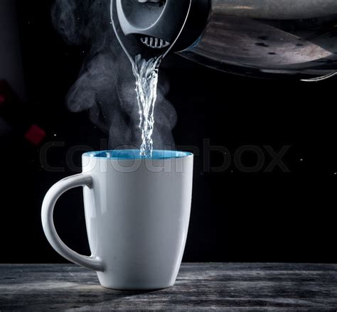 Kettle Pouring Boiling Water Into A Cup With Smoke On Wood Table Stock Image Colourbox