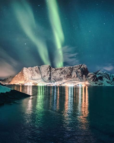 Aurora Borealis Northern Lights Over Snowy Mountain With Glowing