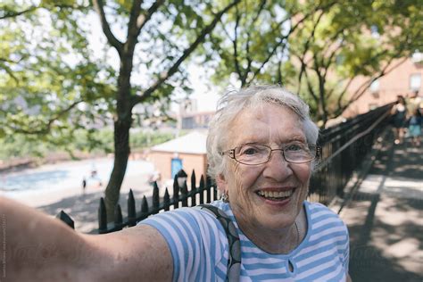 Portrait Of Smiling Healthy Senior Citizen Woman Using Camera