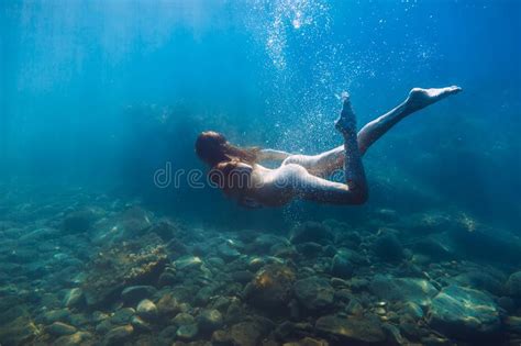 Beautiful Naked Woman Swimming Underwater In Blue Ocean Stock Photo