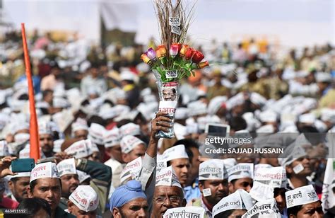 A Supporter Of The Aam Aadmi Party Holds A Broom Decorated With News