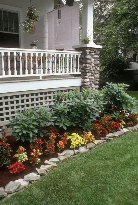A Front Yard Garden With Flowers And Plants On The Side Of The House