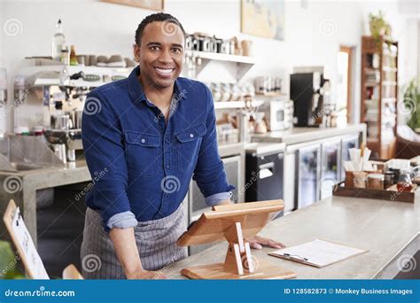 Young Black Male Coffee Shop Owner Leaning Behind Counter Stock Image