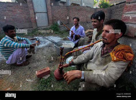 A Kashmiri Cook Or Waza Smokes A Hookah As He Along With Others