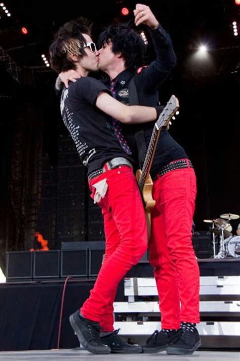 Two Young Men Are Kissing On Stage With Guitars