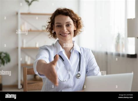 Portrait Of Smiling Female Doctor Stretch Hand For Handshake Stock