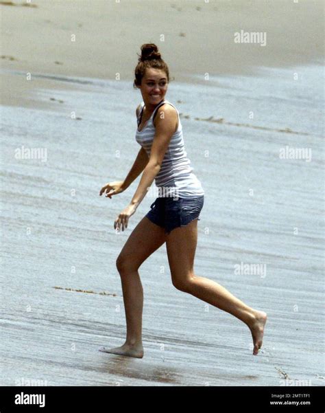 miley cyrus frolics in the surf with friends castmates while filming her latest hannah montana