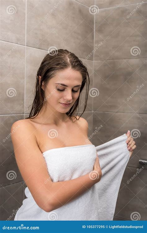 Девушка оборачивая полотенце вокруг тела Стоковое Изображение