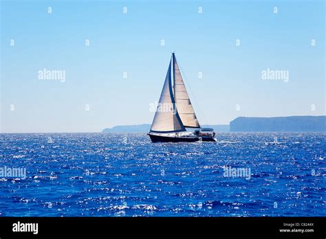 Blue Mediterranean Sailboat Sailing In Perfect Ocean At San Antonio