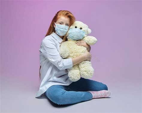 Red Haired Girl And A Teddy Bear In Medical Masks The Concept Of