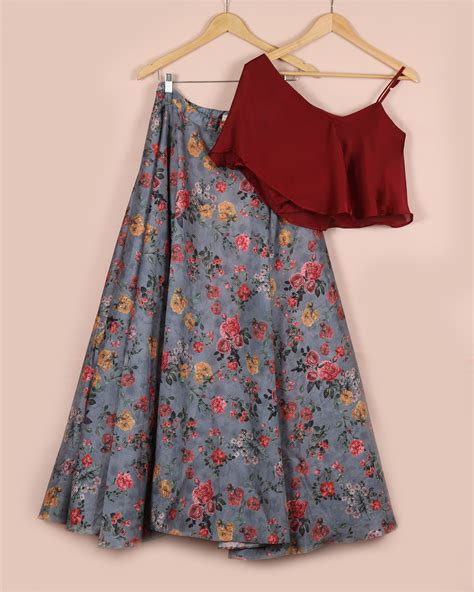 a stunning crop top with a cape shoulder is paired with a beautiful floral print skirt the top