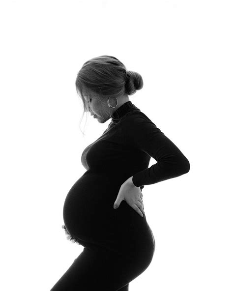 a pregnant woman is standing with her hands on her hips