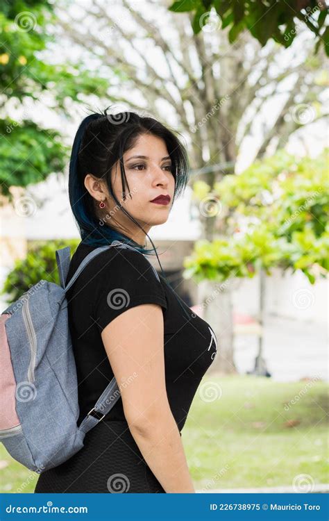 Universitaria Latina Con El Pelo Azul Caminando Por El Parque Vestido Con Una Bolsa Negra Y Azul