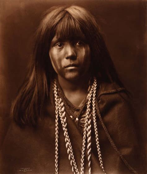 An Old Black And White Photo Of A Native American Woman With Long Hair Wearing Necklaces