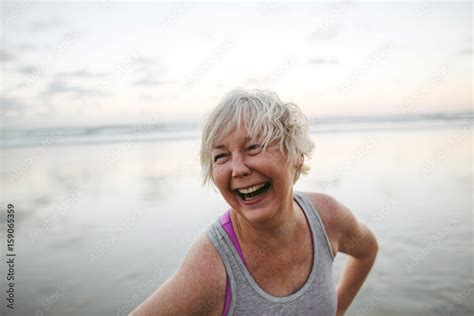 Vibrant Mature Woman Enjoying Herself On The Beach At Sunset Stock