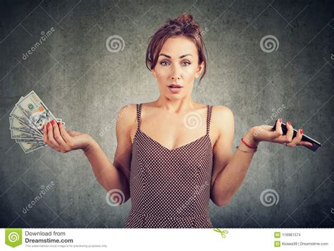 Displeased Woman Holding Smart Phone And Money Dollar Cash Unhappy With Cellular Service