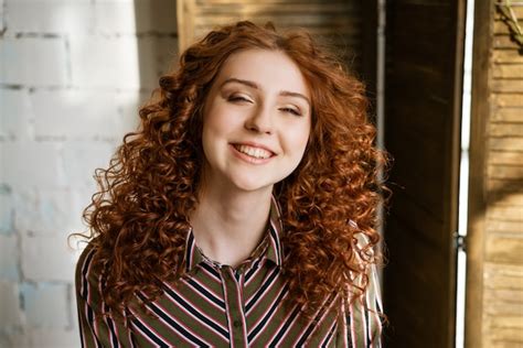 Premium Photo Portrait Of Happy Redhead Curly Young Woman Near Window