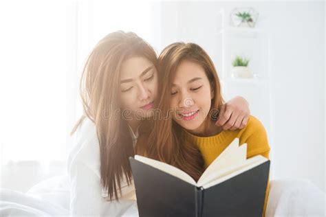 belle giovani coppie felici lesbiche asiatiche delle donne lgbt che si siedono insieme sul libro