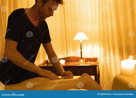 Massage In Spa Salon A Man Massages A Leg Of His Woman Client Stock